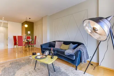 a living room with a blue couch and a table at Sweett - Calabria in Barcelona