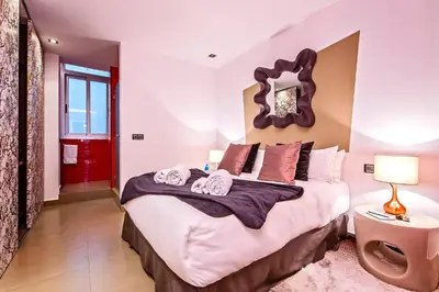 a bedroom with a large bed and a red door at Sweett - Urqui City Center in Barcelona