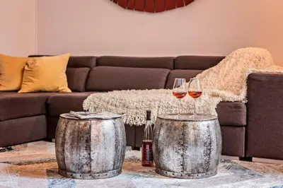 two wine glasses on two metal drums in front of a couch at Sweett - Urqui City Center in Barcelona