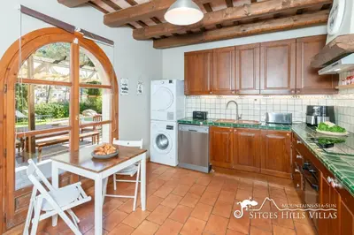 a kitchen and living room with a table and chairs at Charming Villa Tamarindo in Olivella