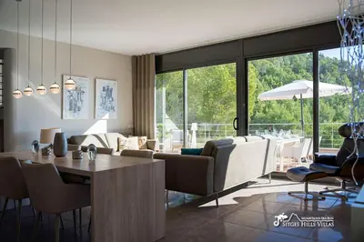 a patio with chairs and a table on a balcony at Villa Valentino Modern Villa with heated pool in Olivella