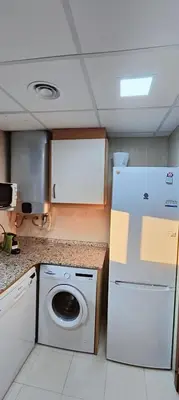 a kitchen with a white refrigerator and a washing machine at Vilanova Beach Stay in Vilanova i la Geltrú
