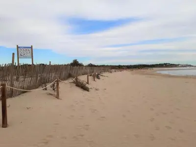 a beach with a fence and a volleyball net at Vilanova Beach Stay in Vilanova i la Geltrú