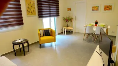 a living room with a yellow chair and a table at Apartamento zona playa de San Sebastian in Sitges
