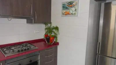 a kitchen with a stove and a red counter top at Apartamento zona playa de San Sebastian in Sitges