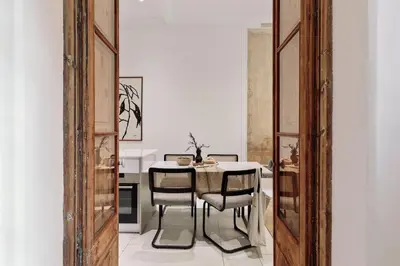 a kitchen with a wooden door and a table at Reus - 1 bedroom in Ciutat Vella in Barcelona