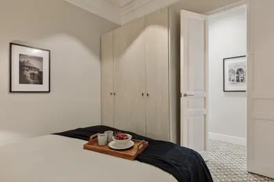 a bedroom with a bed with a tray of food on it at Maslak - 2 bedrooms in Eixample Antiga in Barcelona