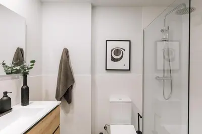 a white bathroom with a shower and a toilet at Tauca - 2 bedrooms and office in Eixample Dreta in Barcelona