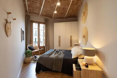 a bedroom with a bed and a table with a lamp at Malay - 3 bedrooms in Eixample Dreta in Barcelona