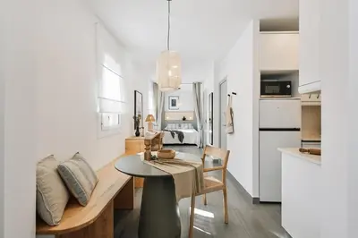 a kitchen and living room with a table and a dining room at Soffio - Studio and terrace in Gràcia in Barcelona
