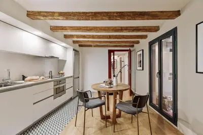 a dining room with a table and chairs and a tv at Vila - 3 bedrooms and office in El Born in Barcelona