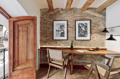 a mirror reflecting a living room with a table and a couch at Vila - 3 bedrooms and office in El Born in Barcelona
