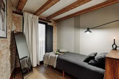 a room with a wooden table and chairs and a brick wall at Vila - 3 bedrooms and office in El Born in Barcelona