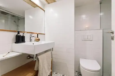 a bedroom with a large bed with gray cabinets at Vila - 3 bedrooms and office in El Born in Barcelona