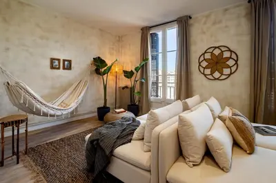a bedroom with a bed and a chair and a table at Natuna - 3 bedrooms in Eixample Esquerra in Barcelona