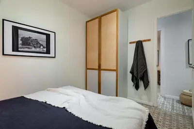a bedroom with a bed with a window and two stools at Natuna - 3 bedrooms in Eixample Esquerra in Barcelona