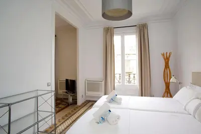 a white bedroom with a white bed and a window at BarcelonaForRent The Claris Suites II in Barcelona