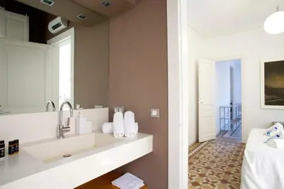 a bathroom with a sink and a mirror at BarcelonaForRent The Claris Suites II in Barcelona