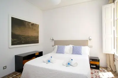 a bedroom with a white bed with two towels on it at BarcelonaForRent The Claris Suites II in Barcelona