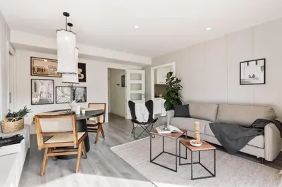 a living room with a tv on a white cabinet at Cervantes - 1 bedroom and pool in Les Corts in Barcelona