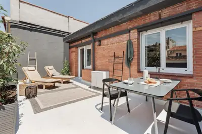a patio with chairs and a table on a balcony at Aura - 3 bedrooms and terrace in Sant Gervasi in Barcelona
