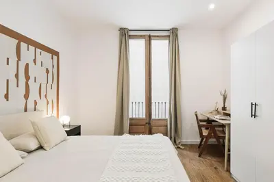 a white bedroom with a bed and a desk at Velino - 4 bedrooms and office in Sant Antoni in Barcelona