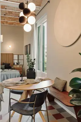 a kitchen with white cabinets and a table at Yaki - 2 bedrooms and balcony in Eixample Dreta in Barcelona