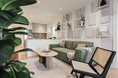 a living room with a green couch and a table at Champey - 2 bedrooms and balcony in Sant Gervasi in Barcelona