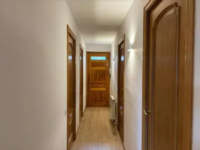 an empty hallway with wooden doors and wooden floors at Can Bosquet - Casa de invitados adosada a casa familiar in Corbera de Llobregat