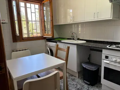 a kitchen with a sink and a table with chairs at Can Bosquet - Casa de invitados adosada a casa familiar in Corbera de Llobregat