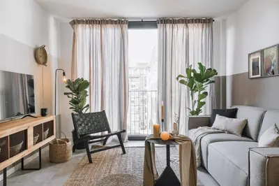 a living room with a couch and a tv at Atalaya - 2 bedrooms in Eixample Esquerra in Barcelona