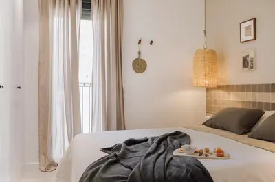 a bedroom with a bed with a tray of food on it at Atalaya - 2 bedrooms in Eixample Esquerra in Barcelona