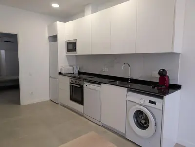 a kitchen with white cabinets and a washing machine at Cal Ticó, 6 guests Monistrol de Montserrat in Monistrol