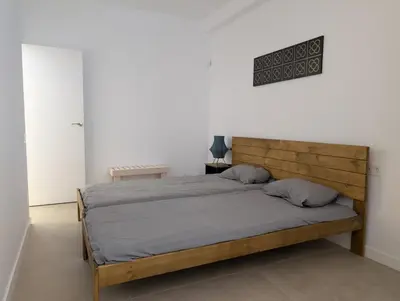a bedroom with a bed with a wooden headboard at Cal Ticó, 6 guests Monistrol de Montserrat in Monistrol