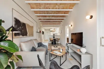 a living room with a couch and a tv at Rothko - 2 bedrooms and office in Eixample Dreta in Barcelona