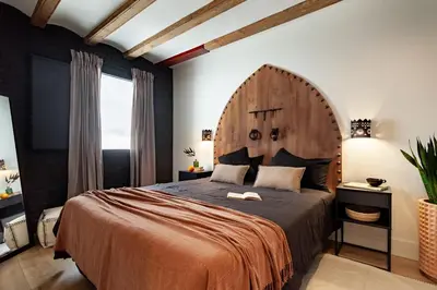 a bedroom with a large bed with a wooden headboard at Anfa - 2 bedrooms in El Born in Barcelona