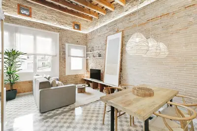 a living room with a couch and a brick wall at Maiori - 2 bedrooms and terrace in Sant Gervasi in Barcelona