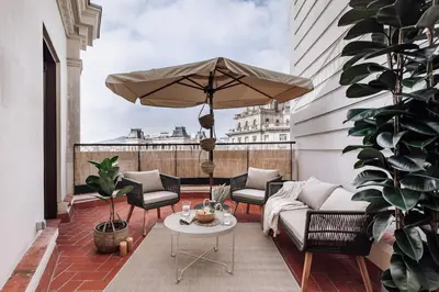 a balcony with a patio furniture and an umbrella at Arjona - 3 bedrooms in Eixample Dreta in Barcelona