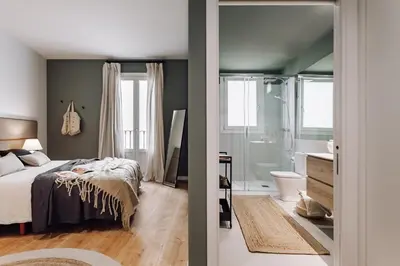 a bedroom with a bed and a bathroom with a shower at Arjona - 3 bedrooms in Eixample Dreta in Barcelona