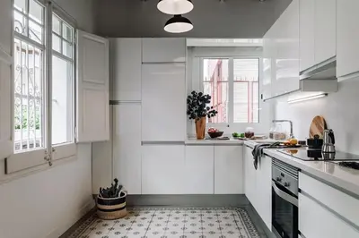 a white kitchen with white cabinets and windows at Ossau - 3 bedrooms in Sant Gervasi in Barcelona