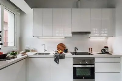 a white kitchen with white cabinets and a sink at Ossau - 3 bedrooms in Sant Gervasi in Barcelona