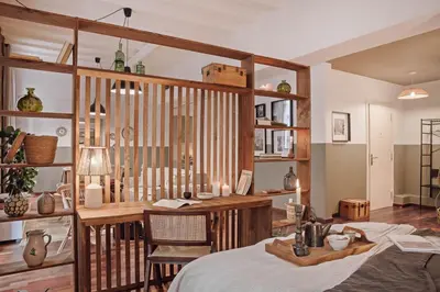 a room with a wooden partition with candles and shelves at Ubrique - Studio in El Born in Barcelona
