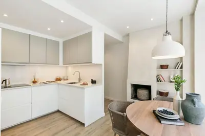 a kitchen with white cabinets and a wooden table at Conca - 2 bedrooms apartment in Sant Gervasi in Barcelona