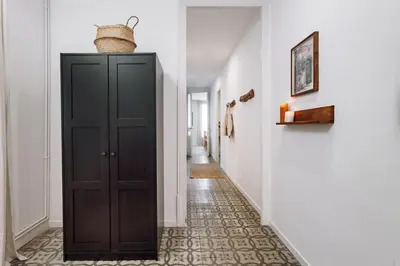a hallway with a black cabinet with a basket on top at Seron - 3 bedrooms and office in Eixample Esquerra in Barcelona