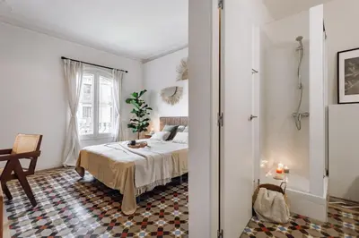 a white bedroom with a bed and a window at Olvera - 3 bedrooms in Eixample Dreta in Barcelona