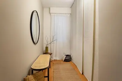 a hallway with a mirror and a table and a chair at Mitaka - 3 bedrooms and terrace in Eixample Dreta in Barcelona