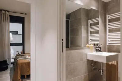 a hallway with three pictures on the wall and a mirror at Pedrera - 2 bedrooms in Eixample Esquerra in Barcelona