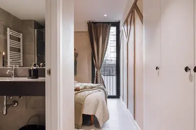 a bathroom with a shower and a toilet and a bedroom at Pedrera - 2 bedrooms in Eixample Esquerra in Barcelona