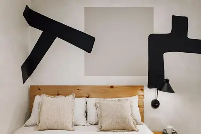 a bedroom with a bed with a black cross above it at Mont - 2 bedrooms and office in Eixample Esquerra in Barcelona