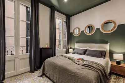 a chair in a room with a large window at Cira - 2 bedrooms and balcony in Vila de Gràcia in Barcelona